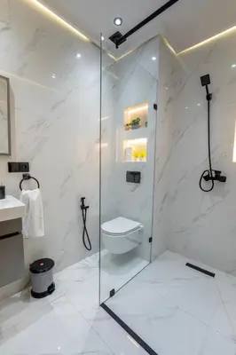 a bathroom with a toilet and a glass shower at Charming Central 2 Bedroom Apartment with Pool Near Train Station in Marrakech
