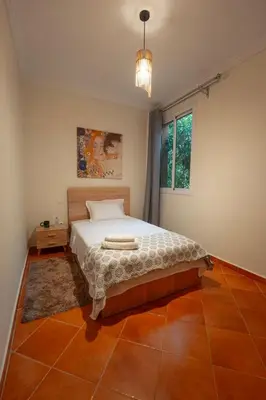 a bedroom with a bed and a window at Charming Central 2 Bedroom Apartment with Pool Near Train Station in Marrakech