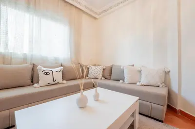a living room with a couch and a table at Charming Central 2 Bedroom Apartment with Pool Near Train Station in Marrakech