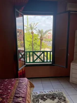 a bedroom with a window with a view of palm trees at Majorele in Marrakech