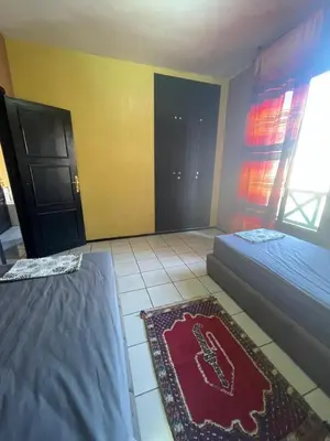 a bedroom with two beds and a rug on the floor at Majorele in Marrakech
