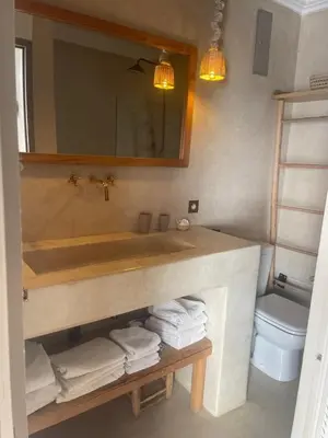 a bathroom with a sink and a toilet and a mirror at Oasis de la Médina -Piscine Chauffée - Climatisation Petit-Déjeuner et Gouvernante in Marrakech