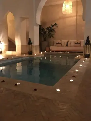 a swimming pool in a living room with a couch at Oasis de la Médina -Piscine Chauffée - Climatisation Petit-Déjeuner et Gouvernante in Marrakech