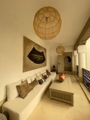 a living room with a white couch and a table at Oasis de la Médina -Piscine Chauffée - Climatisation Petit-Déjeuner et Gouvernante in Marrakech
