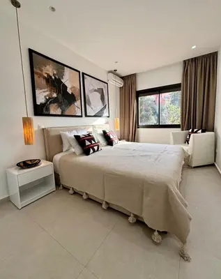 a bedroom with a large bed and two windows at Luxury apartment with swimming pool, Hivernage in Marrakech