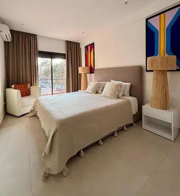 a bedroom with a large bed and a chair at Luxury apartment with swimming pool, Hivernage in Marrakech