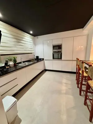 a kitchen with white cabinets and a table with chairs at Luxury apartment with swimming pool, Hivernage in Marrakech