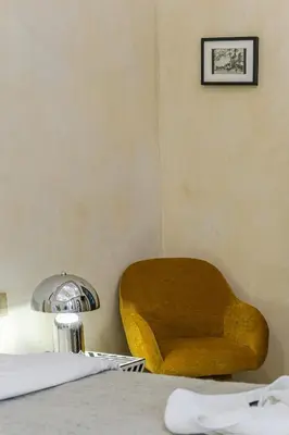 a yellow chair sitting next to a table with a lamp at Riad Layl Marrakech a seulement 2 minutes à pied de la célèbre place Jemaa El Fna in Marrakech