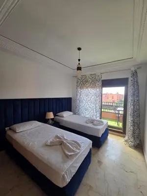 a bedroom with two beds and a large window at andlous 4 in Marrakech