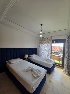 a bedroom with two beds and a large window at andlous 4 in Marrakech
