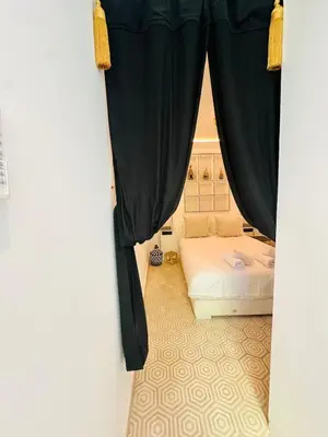 a bedroom with a bed and a window with curtains at Riad Bayas - Comfort & Authenticity in Marrakech