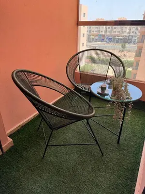 two chairs and a table in a room with a window at appartement vue piscine enjoy & relax in Marrakech