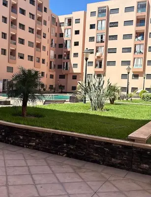 a park in front of a large building at appartement vue piscine enjoy & relax in Marrakech