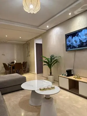 a living room with a couch and a tv on the wall at appartement vue piscine enjoy & relax in Marrakech