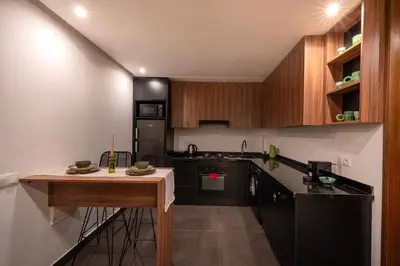 a kitchen with black appliances and wooden cabinets at NEW !!! Organic design apartment-Center Marrakech getaway in Marrakech