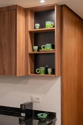 a kitchen with wooden cabinets with green cups and plates at NEW !!! Organic design apartment-Center Marrakech getaway in Marrakech