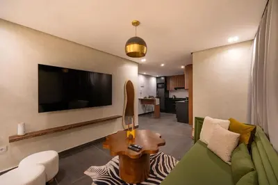 a living room with a couch and a tv at NEW !!! Organic design apartment-Center Marrakech getaway in Marrakech