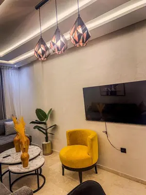 a living room with a yellow chair and a table at דירה
