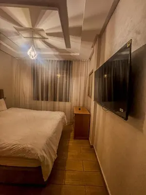a bedroom with a bed and a flat screen tv at דירה