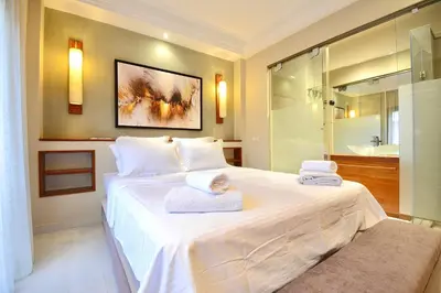 a bedroom with a large white bed with towels on it at 1 King BR with AC, Roof Pool & View-Perfect for 2- City Center in Marrakech