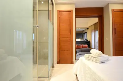 a bathroom with a shower and a bed with towels at 1 King BR with AC, Roof Pool & View-Perfect for 2- City Center in Marrakech