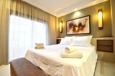 a bedroom with a large white bed with towels on it at 1 King BR with AC, Roof Pool & View-Perfect for 2- City Center in Marrakech