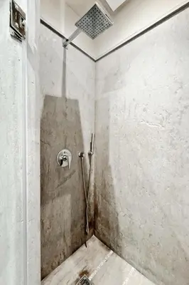 a bathroom with a shower with a hose in a wall at 1 King BR with AC, Roof Pool & View-Perfect for 2- City Center in Marrakech