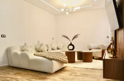 a living room with a white couch and a table at Elegant Luxury Apartment in Marrakech