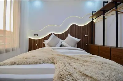 a bedroom with a large white bed with a large headboard at Elegant Luxury Apartment in Marrakech