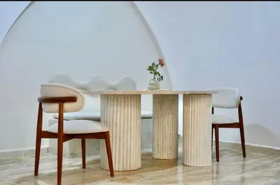 a wooden table with two chairs and a table with a tablewered at Elegant Luxury Apartment in Marrakech