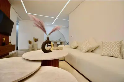 a living room with a white couch and a table at Elegant Luxury Apartment in Marrakech