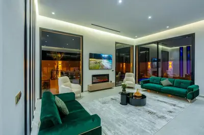 a living room with green couches and a fireplace at Villa Santa Marrakech in Marrakech
