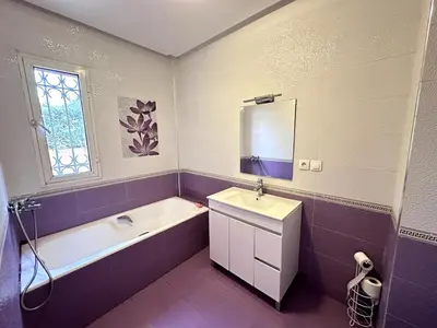 a bathroom with a white sink and a tub and a mirror at Spacious Villa with Private Pool in Oulad Lahsene