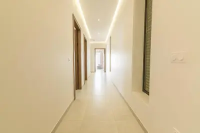 an empty hallway with white walls and white tile floors at Villa Milabel - Piscine et jardin Privée Sans vis-à-vis Wifi HD in Oulad Akkou
