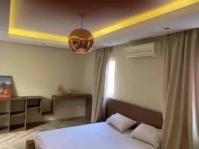a bedroom with a bed and a desk and a light at Riad-style triplex in secure residence in Marrakech