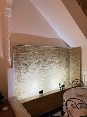 a room with a brick wall with a table and chairs at Riad-style triplex in secure residence in Marrakech