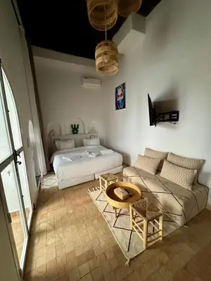 a bedroom with a bed and a couch and a table at riad les cinq terres in Marrakech