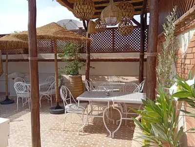 a patio with tables and chairs on a patio at riad les cinq terres in Marrakech