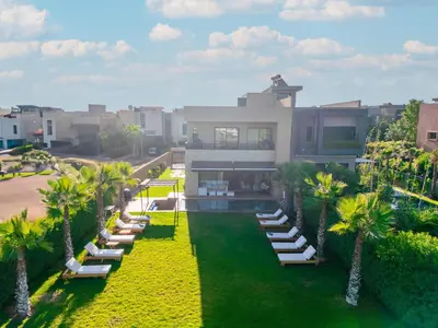 an aerial view of a house with lounge chairs and palm trees at Luxury Villa with Heated Pool & Private cinema in Marrakech
