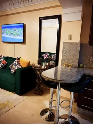 a living room with a green couch and a table at Guéliz Horizon - Central Apartment in Miramas2 in Marrakech