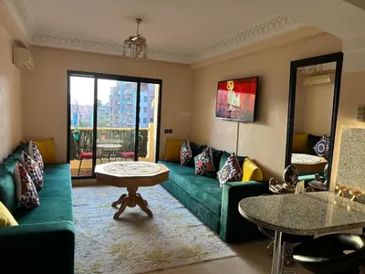 a living room with a green couch and a table at Guéliz Horizon - Central Apartment in Miramas2 in Marrakech