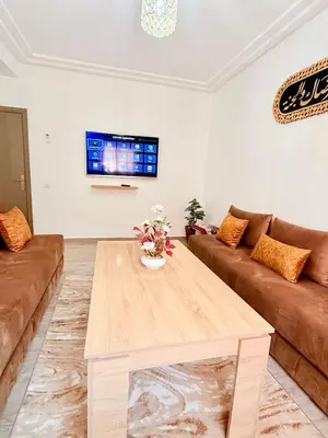 a living room with a table and a couch at A24 Confortable Moderne Au Centre-ville in Marrakech