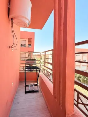 a balcony with a table and a chair on it at A24 Confortable Moderne Au Centre-ville in Marrakech