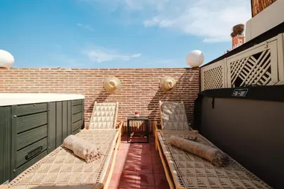 a balcony with two chairs and a brick wall at Riad Les Sultanes Havre de paix avec jacuzzi prive in Marrakech