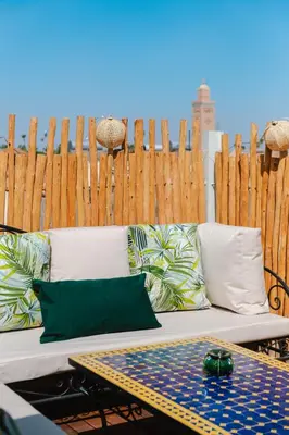 a white couch with pillows and a wooden fence at Riad Les Sultanes Havre de paix avec jacuzzi prive in Marrakech