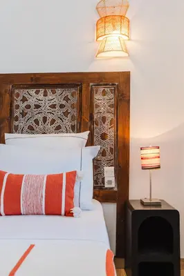 a bedroom with a bed with a wooden headboard and a lamp at Riad Les Sultanes Havre de paix avec jacuzzi prive in Marrakech