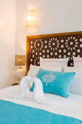 a bedroom with a bed with towel animals on it at Riad Les Sultanes Havre de paix avec jacuzzi prive in Marrakech