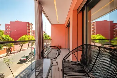 a balcony with two chairs and a view of a street at Modernite et Bien Etre au Coeur de la Ville in Marrakech