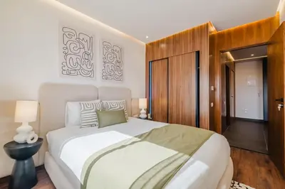 a bedroom with a white bed and a wooden cabinet at Sejour lumineux et moderne dans le centre de Marrakech in Marrakech