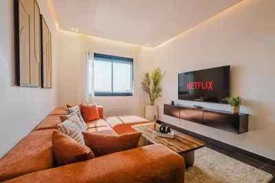 a living room with a couch and a tv at Sejour lumineux et moderne dans le centre de Marrakech in Marrakech
